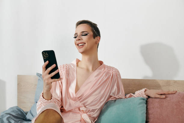istock Young drag queen enjoying a moment at home while checking her phone in a cozy setting 2167874902