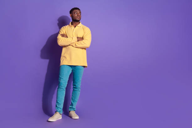 istock Full length photo of handsome young guy look empty space folded hands strict dressed yellow garment isolated on violet color background 2167875182
