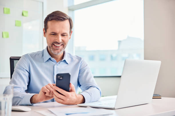 istock Happy professional man looking at his smartphone while working in a modern office. 2167876265