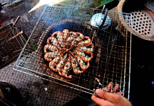 Close up of raw fresh shrimp threaded on skewers, ready for grilling or barbecue, seafood cooking preparation concept