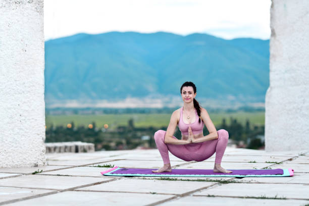 Expert Woman training Yoga in the morning by the sea