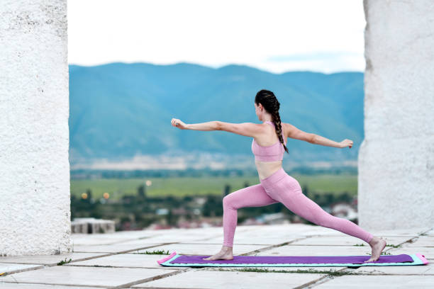 istock Warrior II Position Yogini Exercising Outside 2167881058