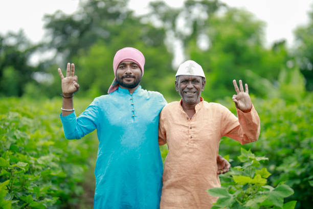 Portrait of happy mid adult farmer holding hoe and gesturing while standing on white background