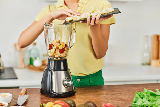 istock Young woman preparing a fresh fruit smoothie in a sunny kitchen during morning hours 2167887918