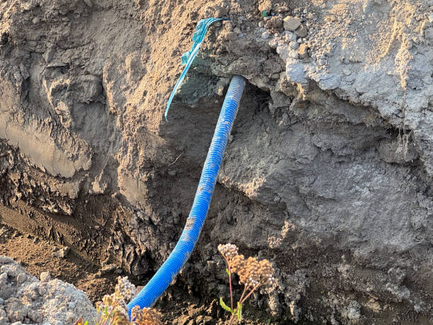 istock A blue corrugated pipe partially exposed in a dirt trench at a construction site 2167888065