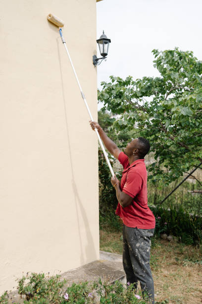 istock African American man painting wall with paint roller 2167888629