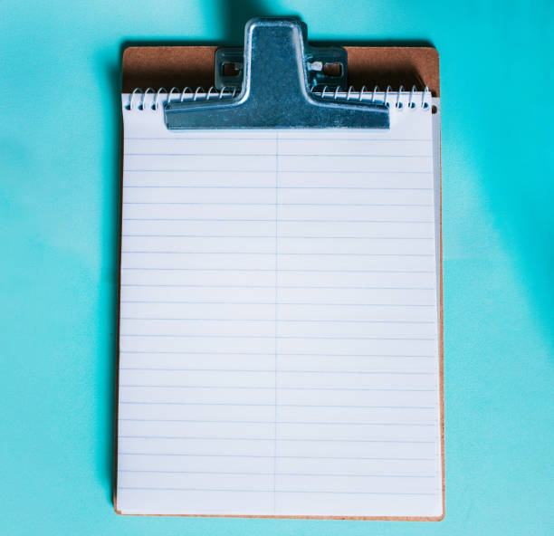 Top view of notepad on isolated background. Note book on clipboard on color background