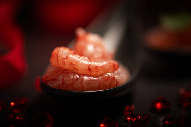 Red Raw shrimps prawns  from Mazara on a black spoon close up
