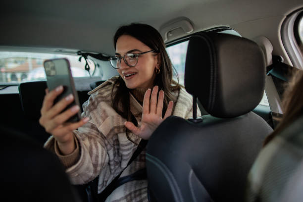 istock Woman riding in a car as a passenger and using her smartphone 2167901317