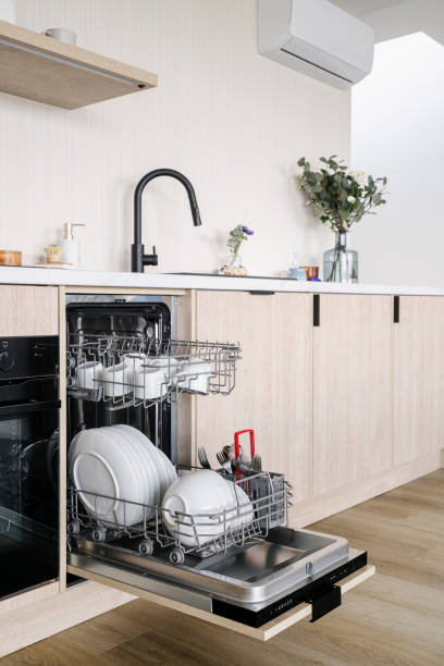 istock Open dishwasher loaded with dishes in kitchen with modern interior 2167902466