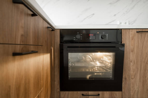 istock Modern kitchen with a black oven and wooden cabinetry during daylight hours 2167902538