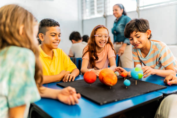istock Child students talking and doing a model of solar system during class at school 2167903906