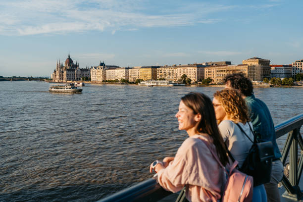 Group of three friends looking at view from the Chain Bridge in the city of Budapest in Hungary. Looking at the Danube river.