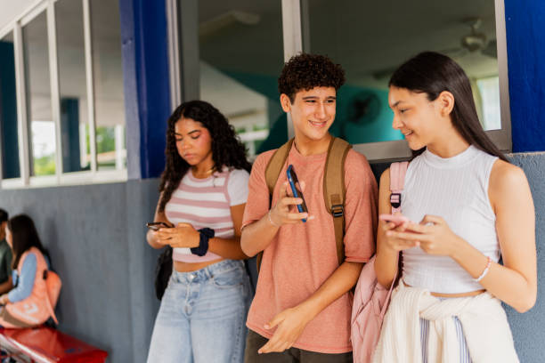 istock Teenage student friends talking and using mobile phone at school 2167906548