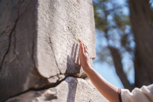 istock Close-up of a hand touching an ancient stone engraved with cuneiform script. 2167914168