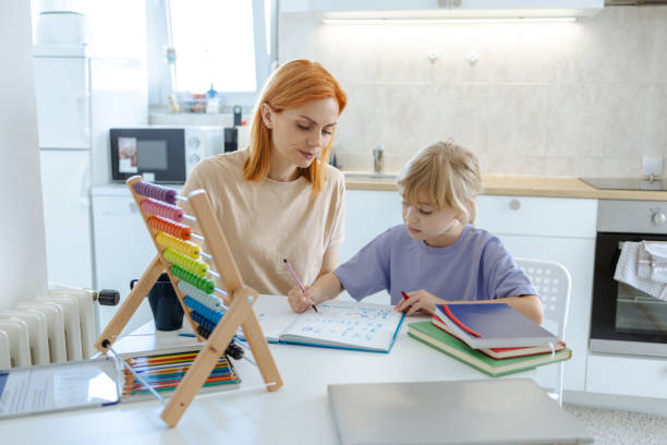 istock Mother helping daughter with homework in modern kitchen setting 2167915242