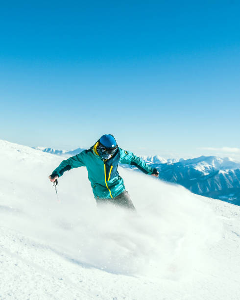 istock Close up vertical banner male skier on piste ski downhill extreme stops pull breaks fast motion in Alps. Active winter holidays, skiing downhill in overcast day. Ski rides on the track with swirls 2167916054