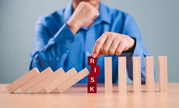 istock Risk assessment crisis concept. Financial analysis solution for real estate business management. Hand stop economic risk. Risk word on wooden block, domino crisis reduce effect. Insurance security 2167916700