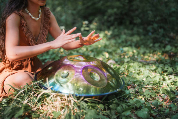 Environmentalist woman playing handpan in forest