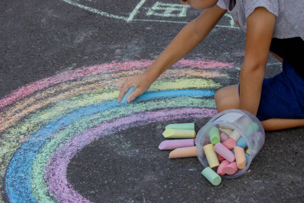 istock the boy draws with chalk on the asphalt. Selective focus 2167920052