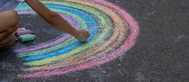 istock the boy draws with chalk on the asphalt. Selective focus 2167920058