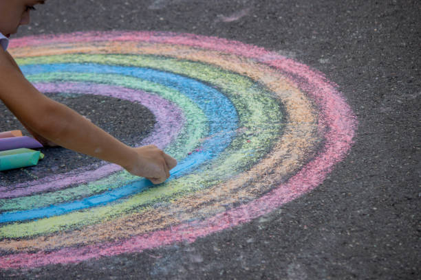 istock the boy draws with chalk on the asphalt. Selective focus 2167920063