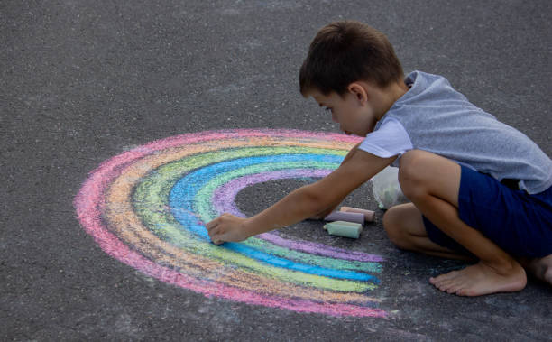 istock the boy draws with chalk on the asphalt. Selective focus 2167920064