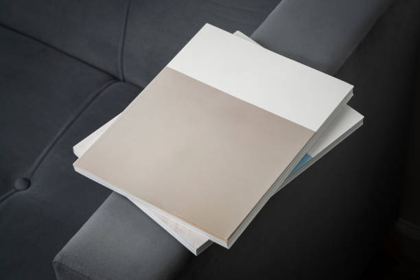 Stack of Magazines on a Black Leather Couch in Soft Light close up