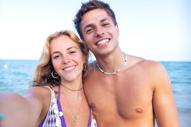istock Two young friends on the beach looking at the camera 2167922273