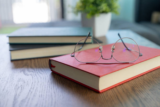 Eyeglasses resting on a stack of books
