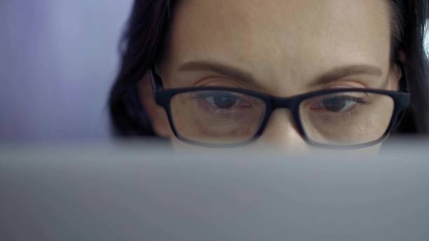 istock Woman with glasses engaged in reading or work, conveying concentration. Front view and close up portrait 2167924444