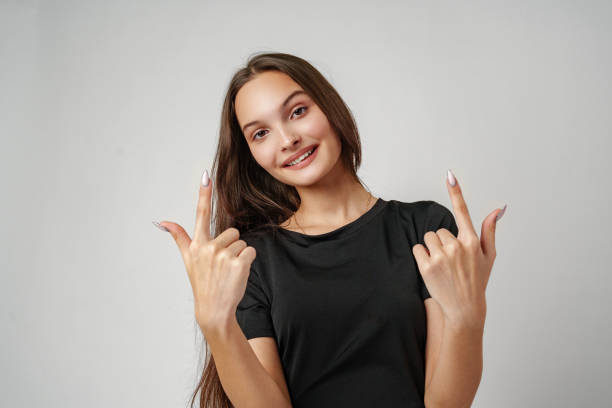 istock Young Woman Pointing to Copy Space Against a Light Background 2167924611