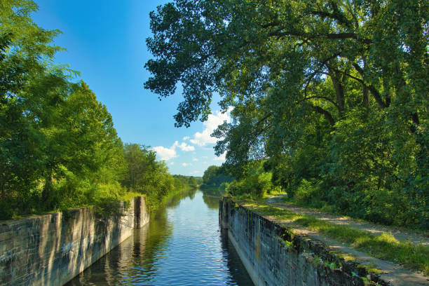 Sunny Summer day landscape of a recreational trail in a lush green forest beside the remains of a lock on the Hennepin Canal in Northern Illinois.