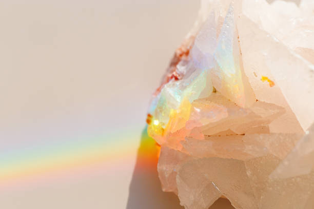 Quartz Prism's Rainbow Reflection at sunlight, close up of clear quartz crystal captures prismatic rainbow, natural facets and beauty of mineral. Minimal aesthetic nature pattern, beige pastel color