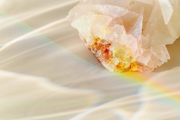 Quartz Prism's Rainbow Reflection at sunlight, close up of clear quartz crystal captures prismatic rainbow, natural facets and beauty of mineral. Minimal aesthetic nature pattern, beige pastel tone