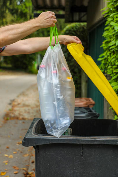 A conscious and responsible person throws plastic waste into a plastic trash bin after sorting the garbage. Sorting waste and its subsequent recycling is an important part of the life of all mankind. una persona consciente y responsable tira los residuos plásticos en un contenedor de basura de plástico después de clasificar la basura. la clasificación de los residuos y su posterior reciclaje es una parte importante de la vida de toda la humanidad.