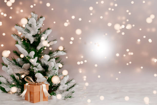 istock Christmas tree with a gift beside it, surrounded by a snowy background and soft glowing lights. 3d rendering 2167932793