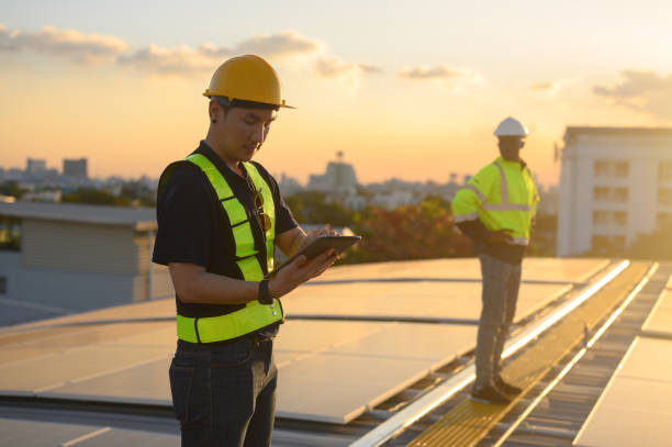 istock Male engineer works installing solar panels on the roof. Engineer or worker working on solar panels or photovoltaic cells on the roof of a business building. 2167932924