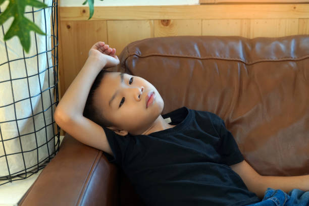 Boy lying in bed watching a movie illuminated by the laptop screen