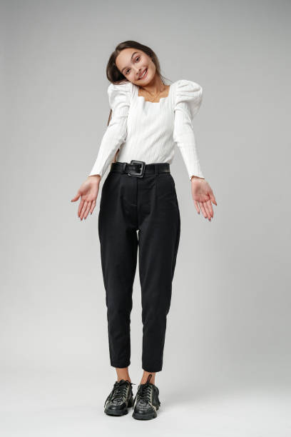 istock Young Woman Wearing White Blouse and Black Pants Posing in Studio 2167937908