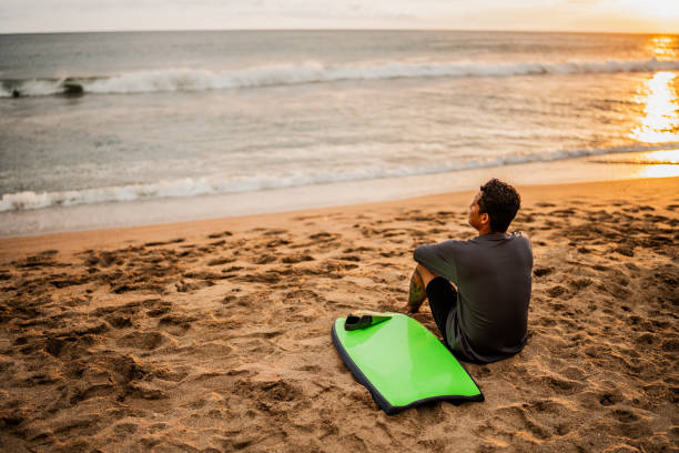 istock Mid adult surfer man contemplating while looking away on the beach 2167941468