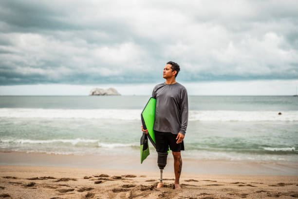 Mid adult surfer man contemplating while looking away on the beach
