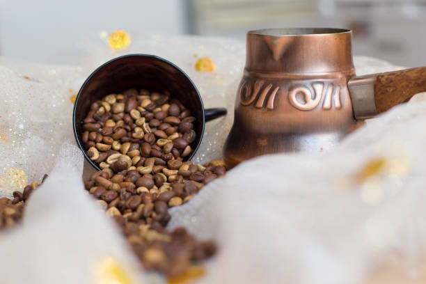 coffee beans are scattered on the table next to the Turk and the cup