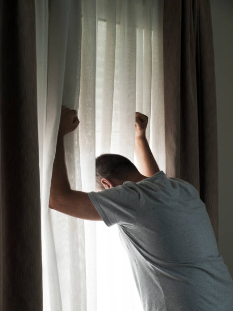 istock A sad and thoughtful man looks out of a window 2167945271