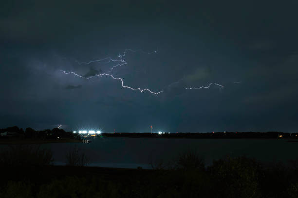 lake lewisville, Texas can be seen on the ground. in distance, water tower, lights, and other properties provide scale of the lightening bolt