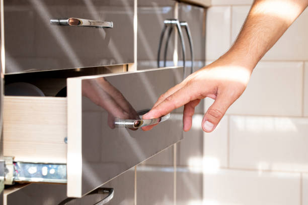 istock Male hand opening brown pull-out kitchen cabinet in kitchen in apartment 2167946016