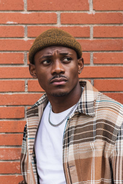istock Stylish black man against brick wall 2167951936