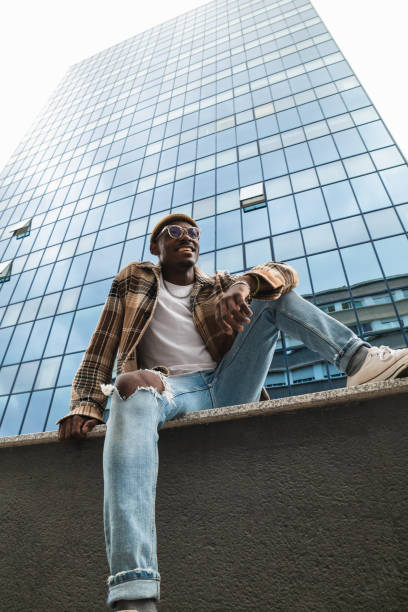 istock Cheerful African American man sitting under skyscraper 2167952039