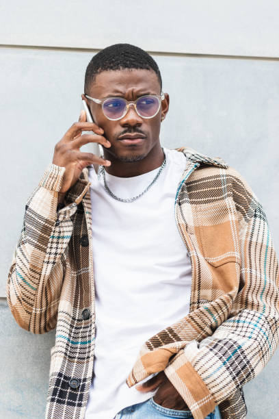 istock Stylish black male using smartphone on street 2167952093