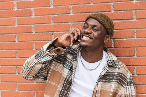 istock Ethnic guy speaking on smartphone near brick wall 2167952162